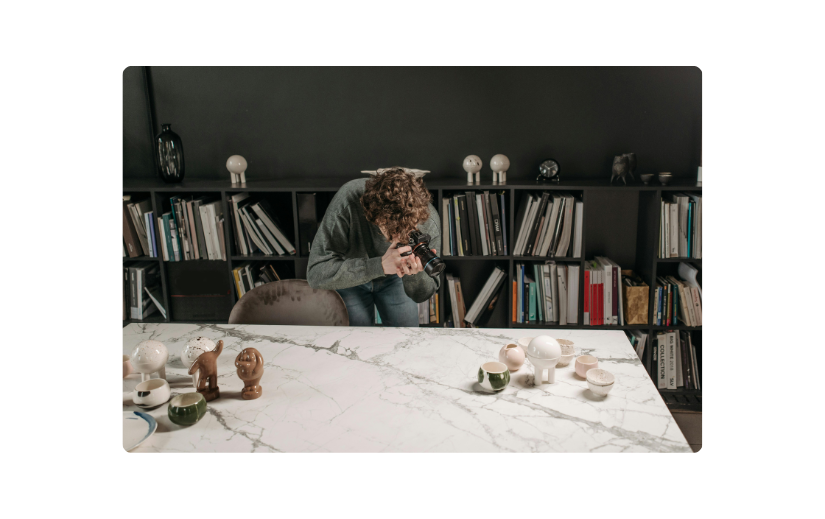 Person photographing ceramics, a great example of Etsy dropshipping or print-on-demand for passive income ideas.